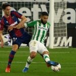 El centrocampista francés del Betis, Nabil Fekir (d), controla el balón ante el disputa el balón ante el jugador montenegrino del Levante, Nikola Vukcevic