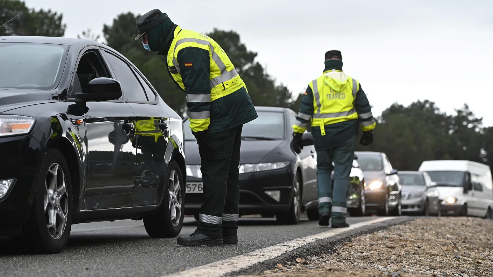 Varios guardias civiles de tráfico montan un control de carretera para controlar las entradas y salidas de Madrid durante la pandemia