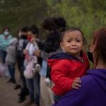 La hondureña Evelyn lleva en brazos a su hija Zoe de 18 meses mientras espera en la frontera con Estados Unidos a ser trasladada a Penitas en Texas para tramitar su solicitud de asilo