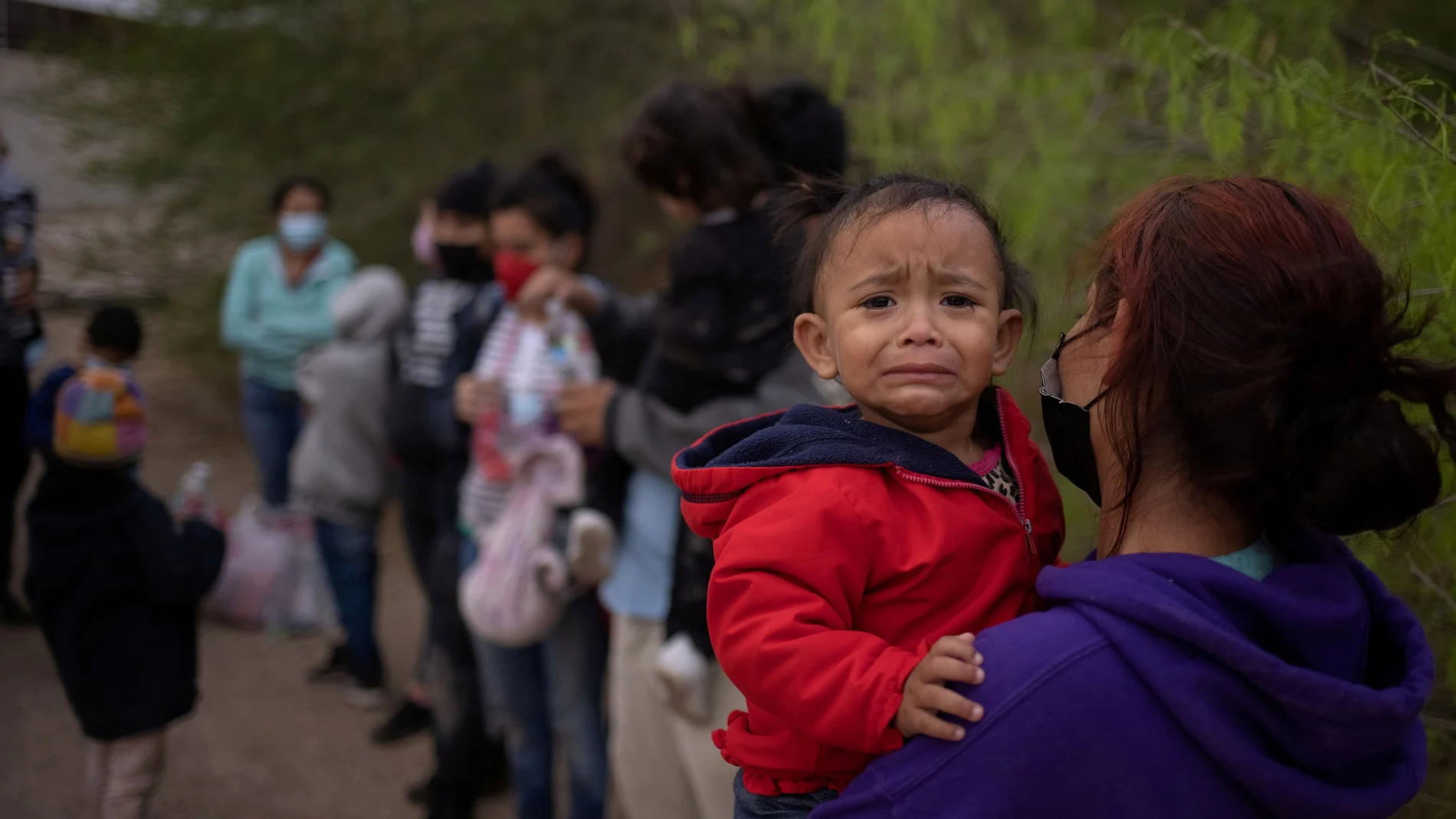 La hondureña Evelyn lleva en brazos a su hija Zoe de 18 meses mientras espera en la frontera con Estados Unidos a ser trasladada a Penitas en Texas para tramitar su solicitud de asilo