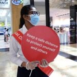 Una mujer con mascarilla recuerda las medidas de seguridad en la reapertura de los centros comerciales en Dubái