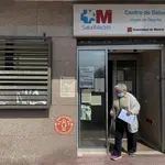 Una mujer sale por la puerta del Centro de Salud Virgen de Begoña perteneciente a la zona básica de salud de Virgen de Begoña, en el distrito de Fuencarral el Pardo.