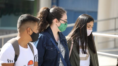 Jóvenes con mascarilla en una calle de Madrid