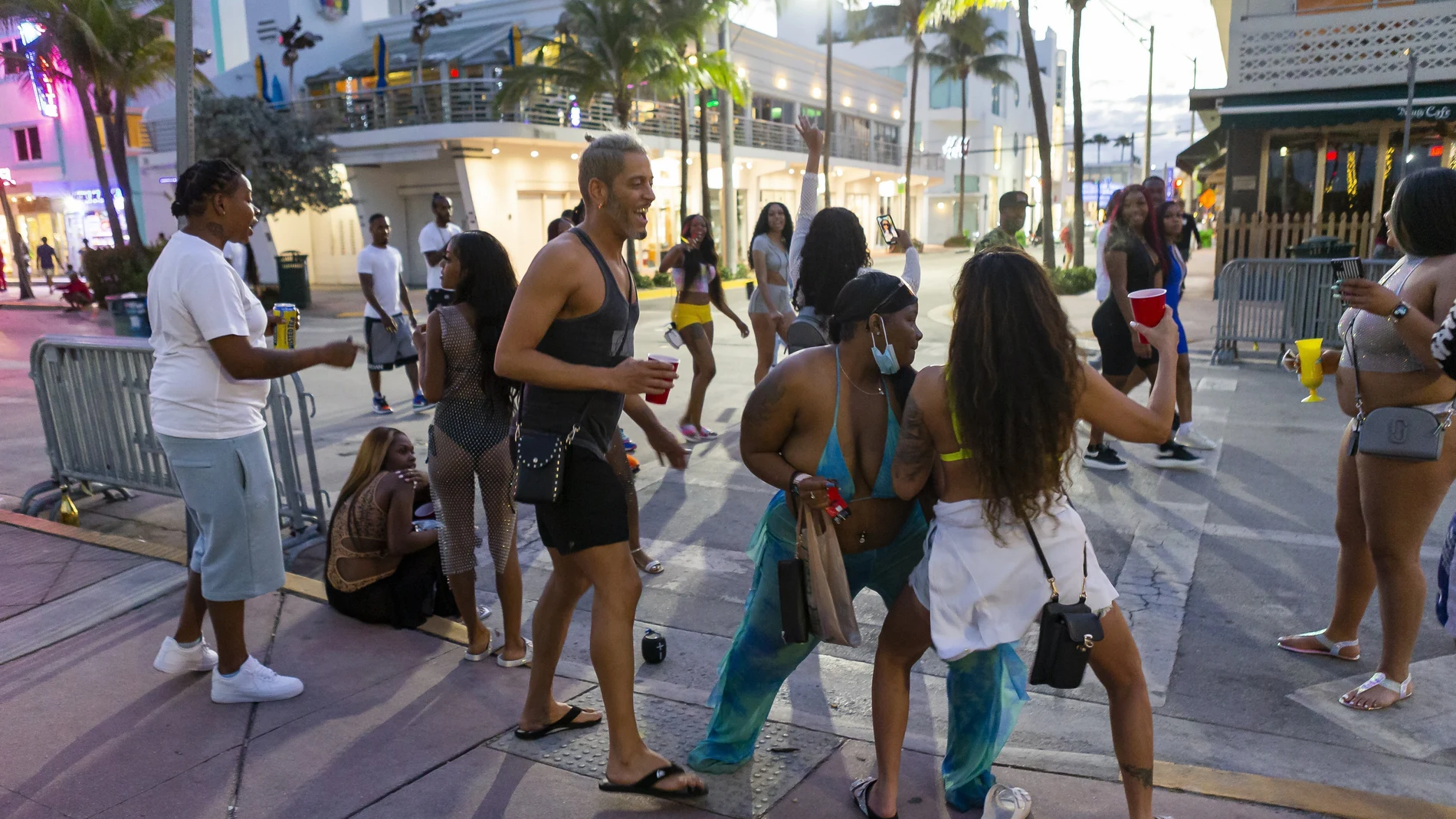 Un grupo de turistas baila en Ocean Drive durante las vacaciones de primavera en Miami Beach, Florida, el lunes 22 de marzo