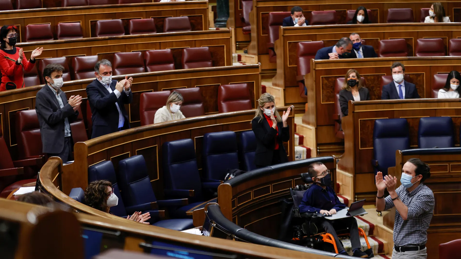 El vicepresidente segundo, Pablo Iglesias (d), recibe los aplausos del Gobierno y de la bancada socialista tras su discurso de despedida.