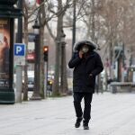 Un hombre pasesa por uno desierto paseo de los Campos Elíseos de París