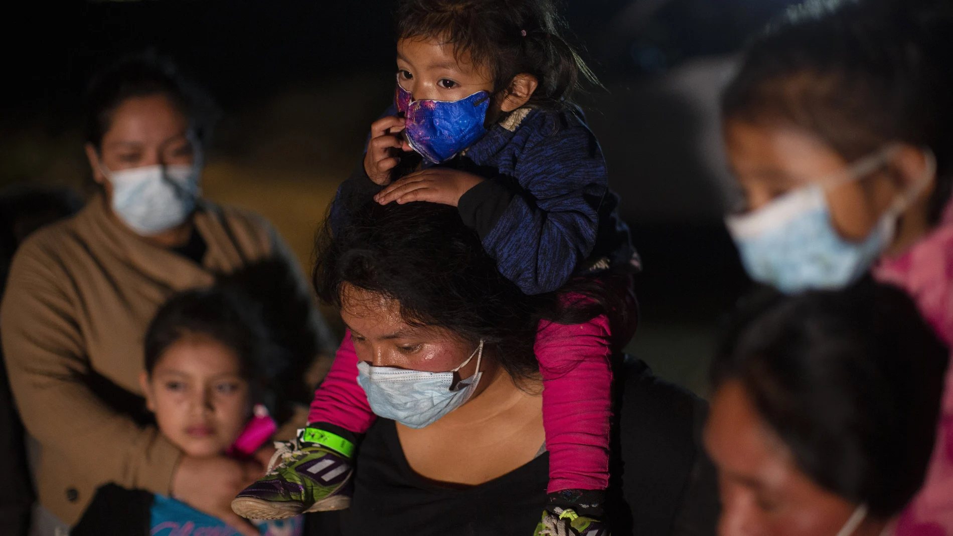 Familias migrantes de Guatemala esperan a una patrulla fronteriza de EE UU después de haber cruzado el Río Grande en una balsa inflable