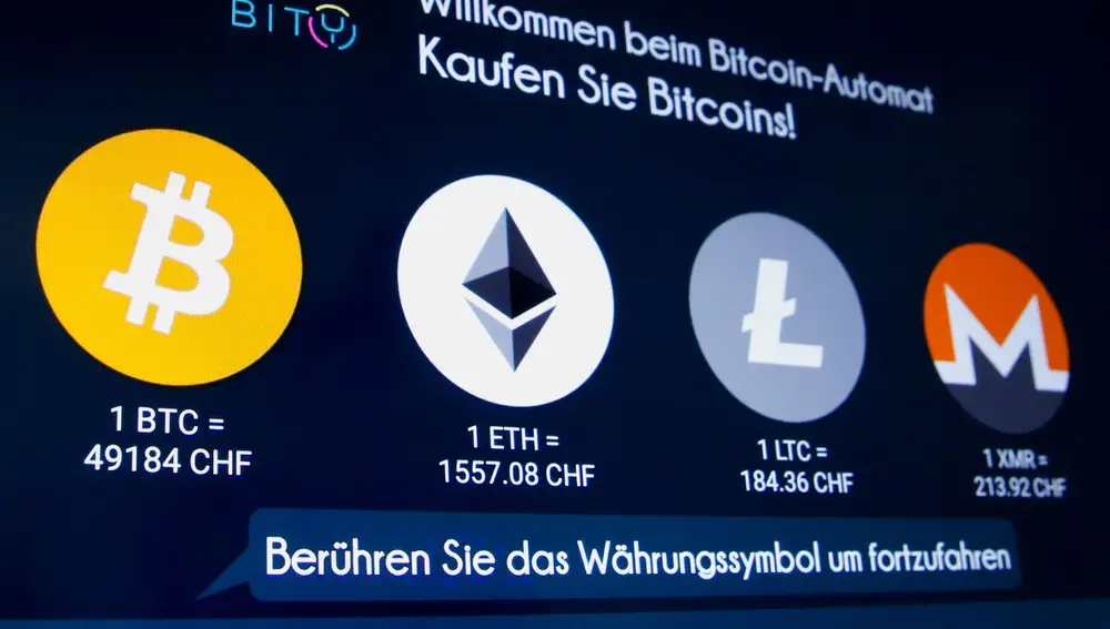 FILE PHOTO: The exchange rates and logos of Bitcoin (BTH), Ether (ETH), Litecoin (LTC) and Monero (XMR) are seen on the display of a cryptocurrency ATM of blockchain payment service provider Bity at the House of Satochi bitcoin and blockchain shop in Zurich, Switzerland March 4, 2021. REUTERS/Arnd Wiegmann/File Photo