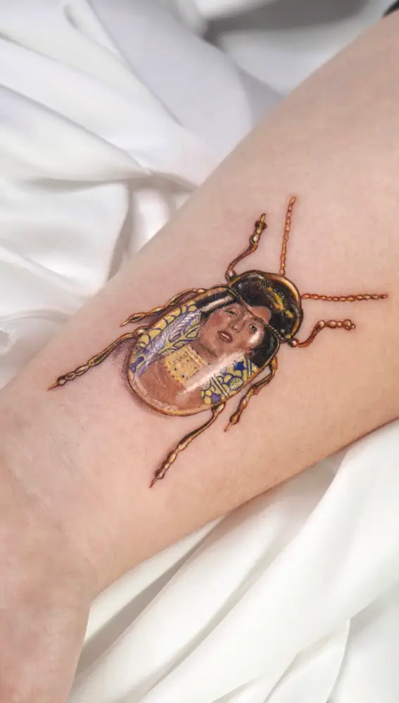 Tatuaje realizado por Caótida de &quot;Judit I&quot;, de Klimt, dentro de un escarabajo