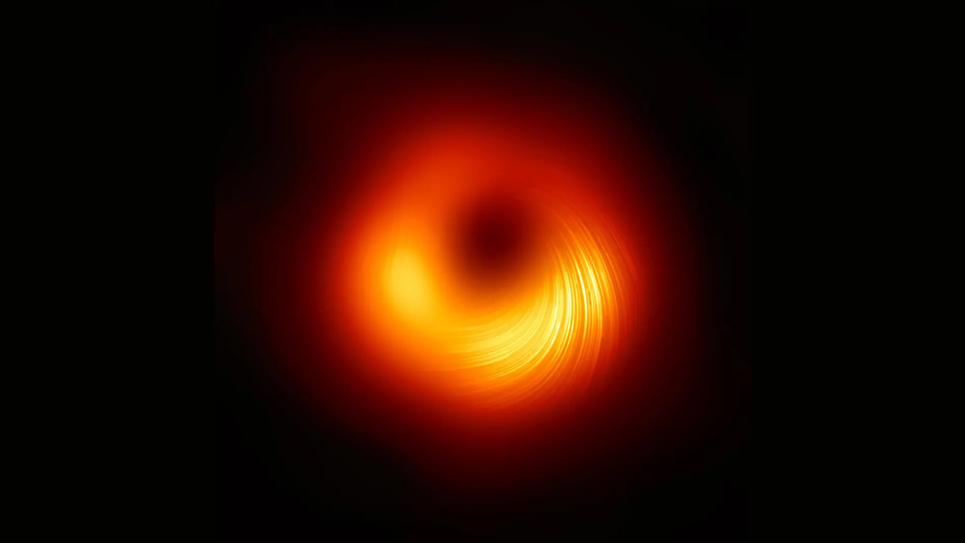 Una vista del agujero negro supermasivo M87 en luz polarizada: las líneas marcan la orientación de la polarización, que está relacionada con el campo magnético alrededor de la sombra del agujero negro.
