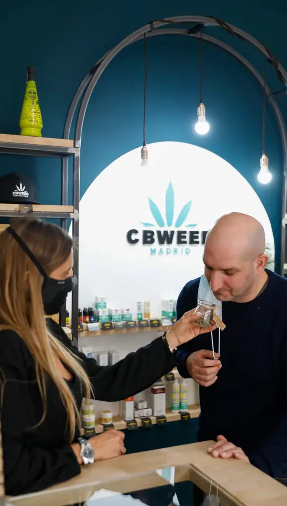 Un cliente huele una de las &quot;flores&quot; de cannabis