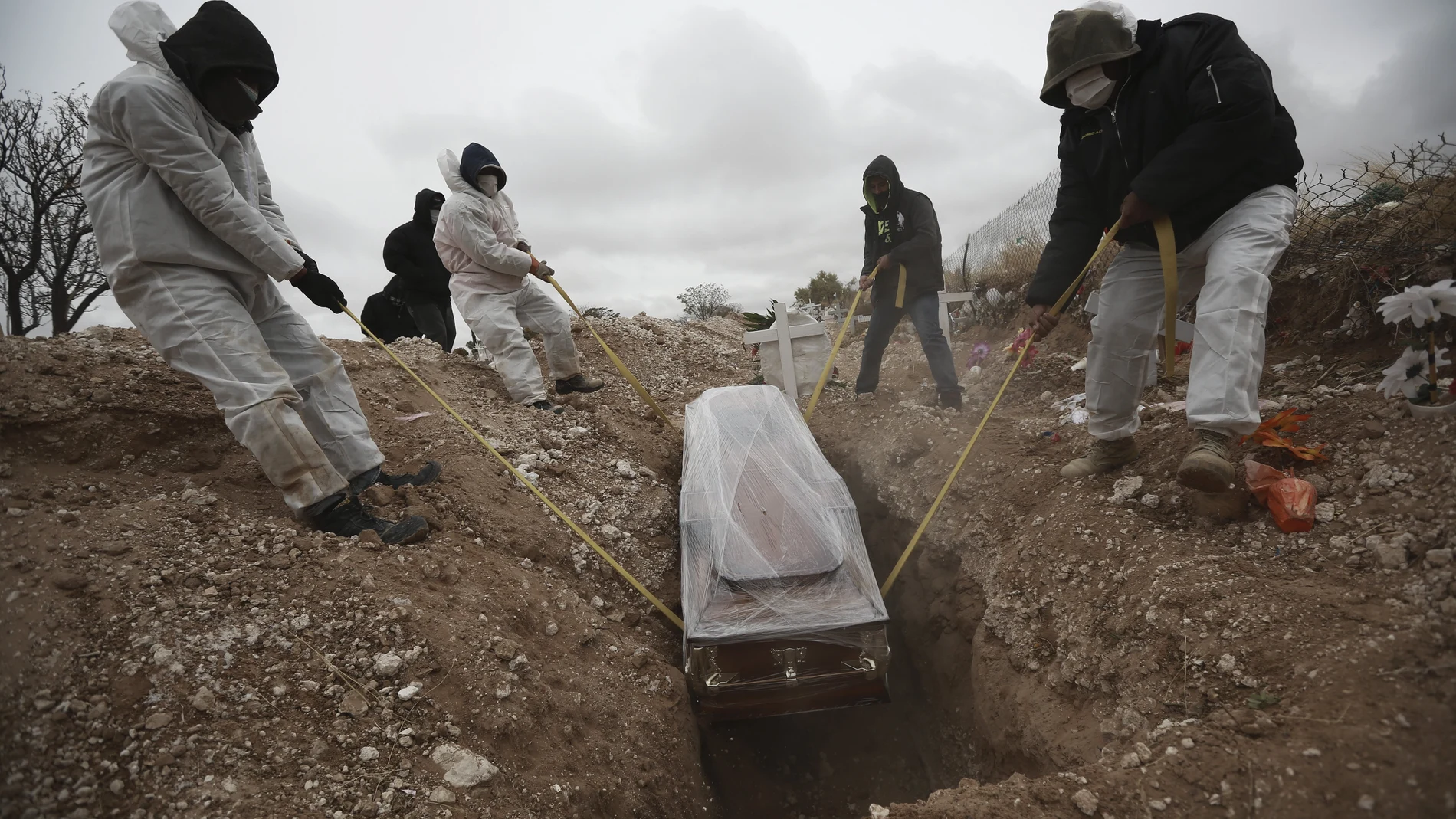 Trabajadores del cementerio de San Rafael, en Ciudad Juárez, entierran a uno de los fallecidos por covid-19