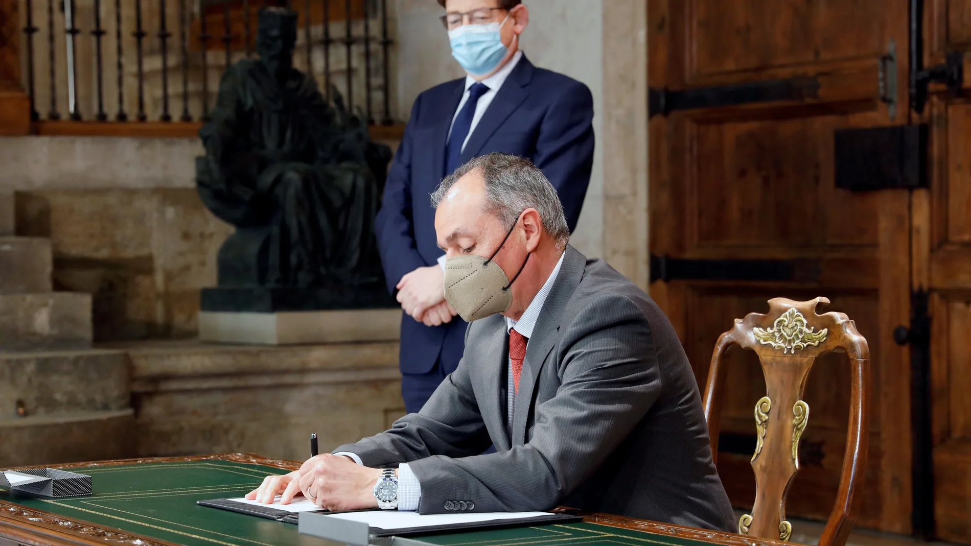 El presidente de la Generalitat, Ximo Puig (c) observa la firma de Salvador Navarro, presidente CEV, del acuerdo entre CCOO-PV, UGT-PV y CEV sobre medidas concretas para la mejora de la economía y el empleo en la Comunitat Valenciana