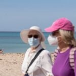 Turistas caminan junto a la playa con mascarilla EFE/ Atienza