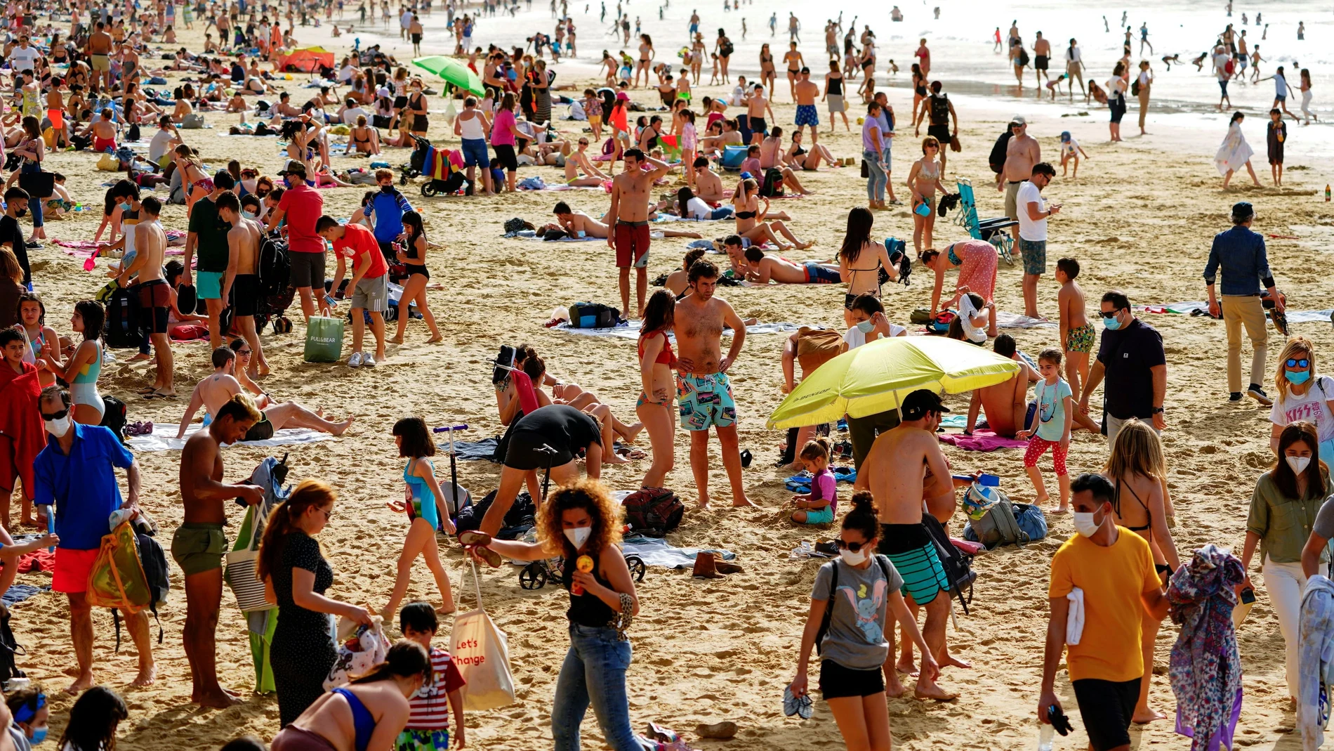 Centenares de personas disfrutan del sol en la playa de La Concha, en San Sebastián