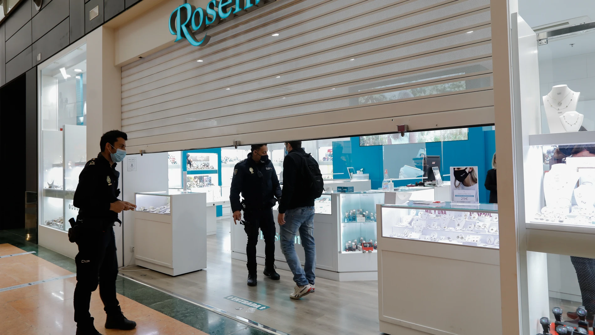 Agentes de la Policía Nacional en la Joyería Roselin en el centro comercial Nueva Condomina momentos después de ser atracada, en Murcia
