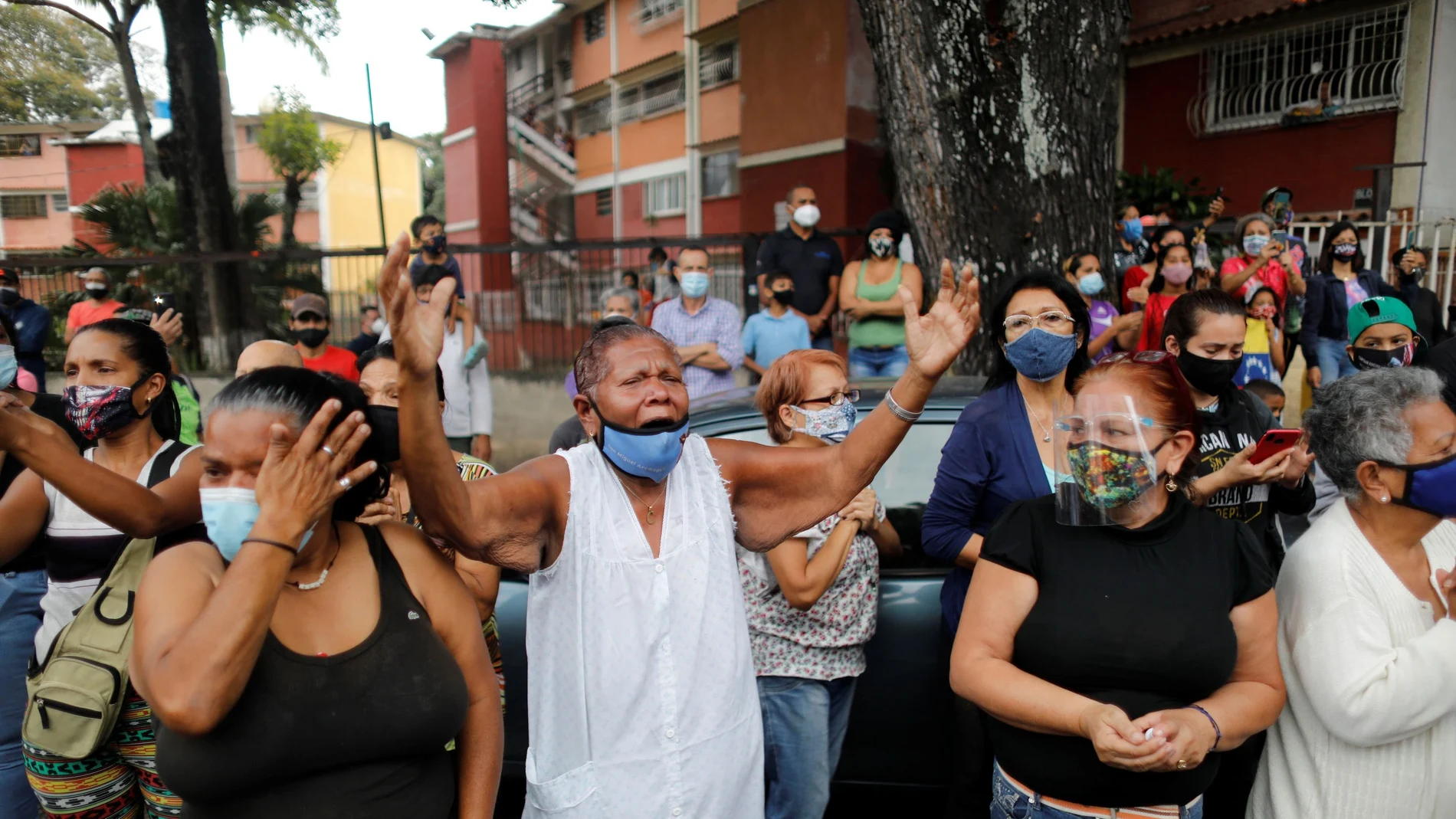 Catholic faithful react as the Popemobile carrying the statue of The Nazarene of St. Paul drives past during Holy Week celebrations in the neighbourhood Catia, in Caracas, Venezuela March 31, 2021. REUTERS/Leonardo Fernandez Viloria NO RESALES. NO ARCHIVES