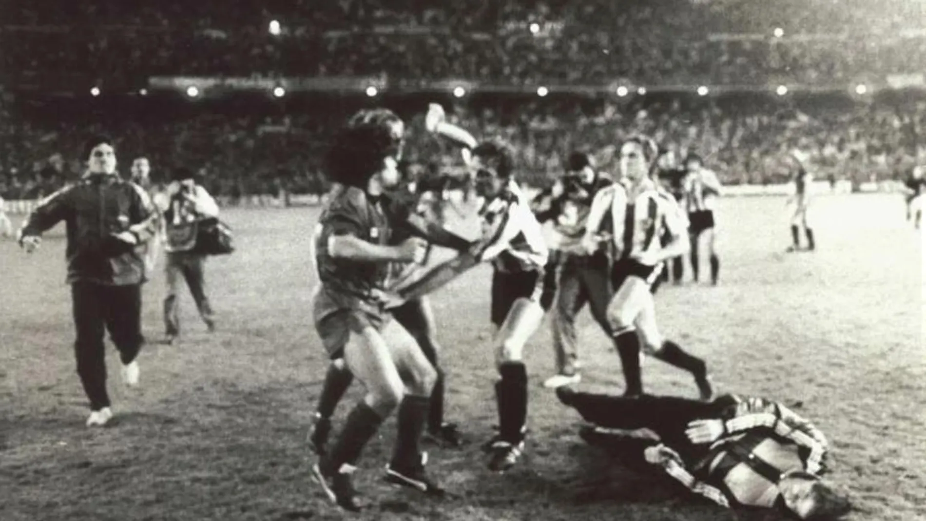 Maradona es perseguido por Núñez y De Andrés después de golpear a Sola, en el suelo con abrigo, tras la final de Copa del 84
