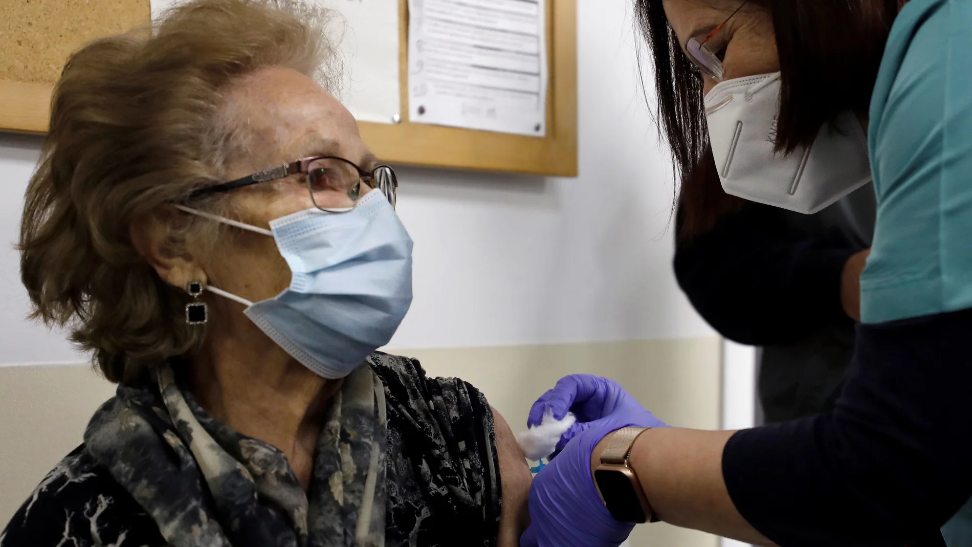 Una sanitaria vacuna a una persona mayor en un ambulatorio de Valencia. La Comunidad Valenciana ha proseguido la pauta de vacunación a los mayores de 80 años, hoy Viernes Santo