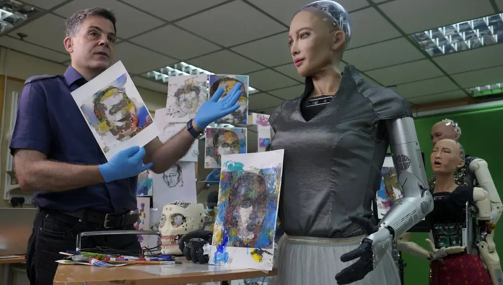 David Hanson, left, creator of Sophia,Â shows a work of Sophia at his studio in Hong Kong on March 29, 2021. Sophia is a robot of many talents â€” she speaks, jokes, sings and even makes art. In March, she caused a stir in the art world when a digital work she created as part of a collaboration was sold at an auction for $688,888 in the form of a non-fungible token (NFT).WLD(AP Photo/Vincent Yu)