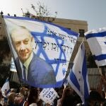 Partidarios del primer ministro israelí ondean una bandera israelí con una imagen de Netanyahu, mientras se reanuda su juicio por corrupción, cerca del Tribunal de Distrito de Jerusalén