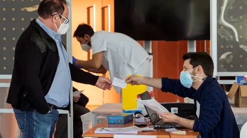 Un hombre muestra su documentación antes de ser vacunado en el Centro Cultural Miguel Delibes de Valladolid