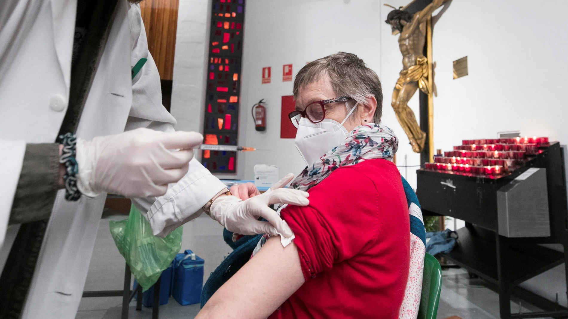 Una mujer recibe una dosis de la vacuna de AstraZeneca en una iglesia zaragozana donde, este lunes