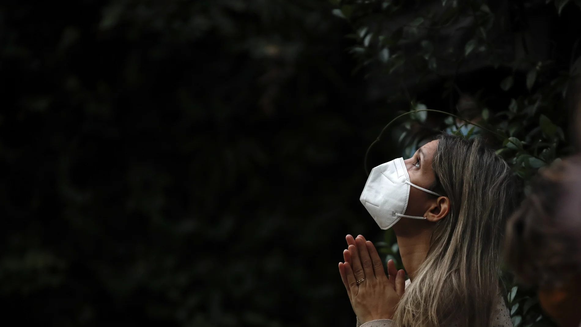 Una mujer con mascarilla reza en Buenos Aires