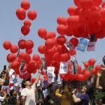 FILE - In this March 22, 2021, file photo, anti-coup protesters release red balloons with notes calling for foreign intervention to help them in Yangon, Myanmar. Many in Myanmar have found a safer, more substantive way to protest the countryâ€™s military coup. Instead of facing down heavily armed soldiers from behind flimsy barricades, they're holding online rummage sales using sites like Facebook. (AP Photo, File)