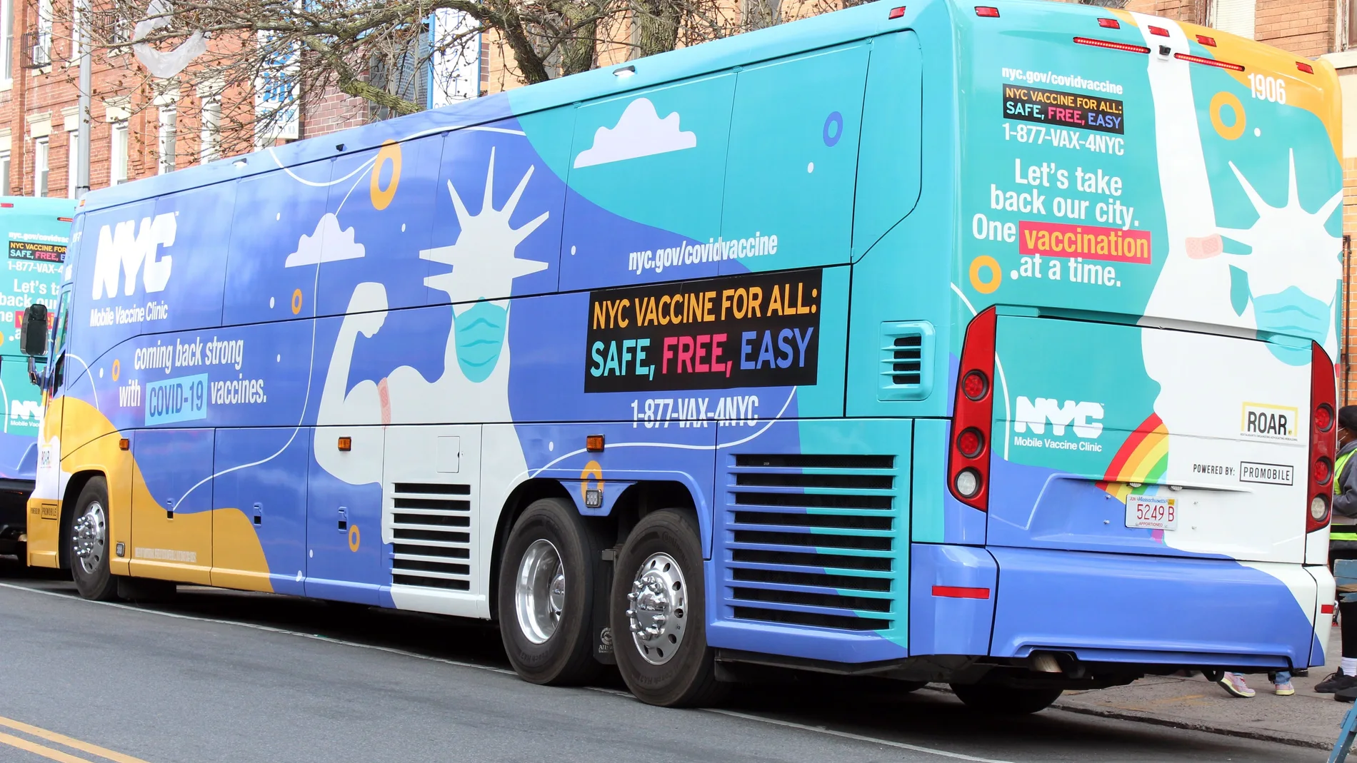 Autobús decorado con un dibujo de la estatua de la Libertad con tapabocas y una tirita en el brazo como señal de que se ha vacunado, uno de los dos autobuses convertidos en unidad móvil para vacunar contra la covid-19, estacionados en Brooklyn, Nueva York (EE.UU)