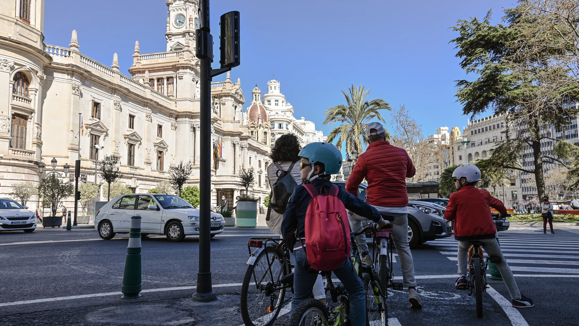 Una familia accede a la plaza del Ayuntamiento en bicicleta