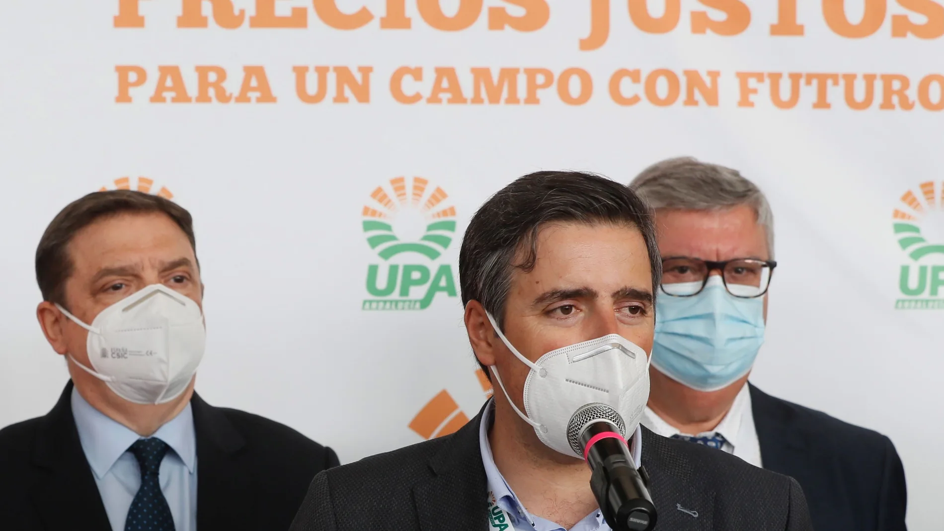 El secretario general de la UPA-Jaén, Cristóbal Cano Martín, durante su intervención tras ser elegido el nuevo secretario general de UPA Andalucía con el 94,2 % de los votos, junto al ministro de Agricultura, Luis Planas (i) y el presidente saliente Miguel Cobos (d)