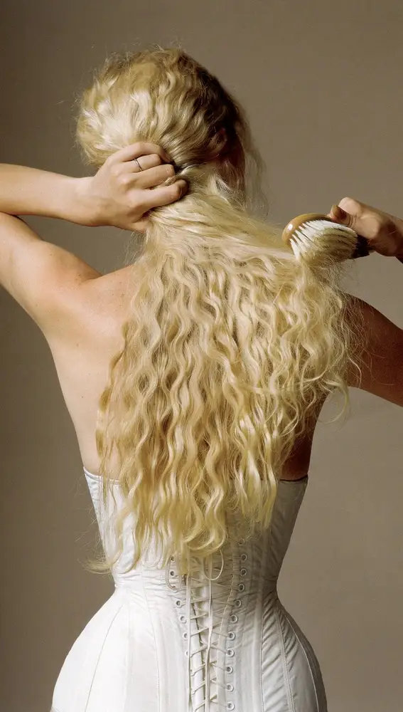 Fotografía de Irving Penn donde se retrata a una mujer desenredándole el pelo