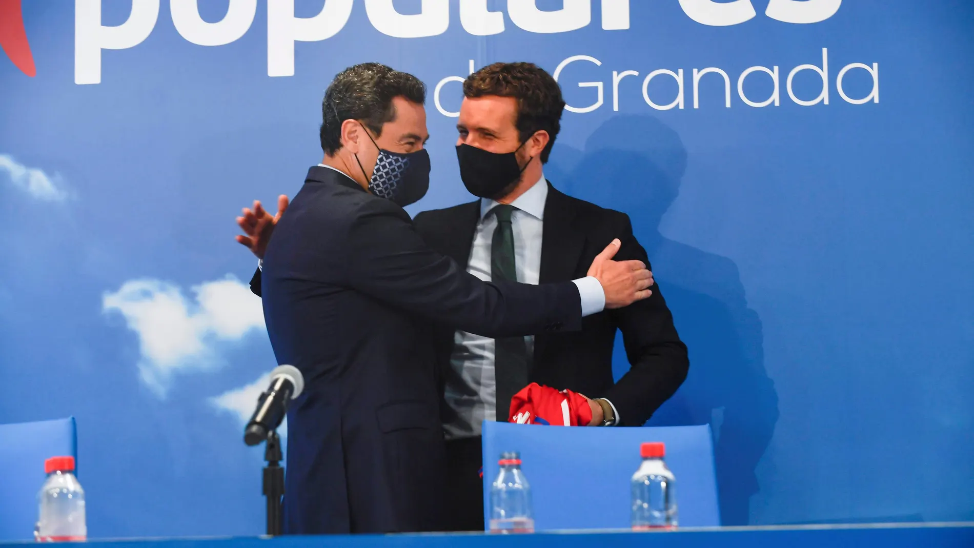 El líder del PP, Pablo Casado, a la derecha, abraza al presidente del PP-A y de la Junta de Andalucía, Juanma Moreno, durante la clausura del consejo provincial de alcaldes y portavoces del PP de Granada