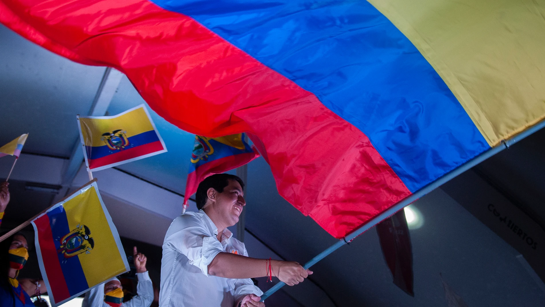 08 April 2021, Ecuador, Quito: Andres Arauz, the presidential candidate in Ecuador, waves a large national flag on stage at the end of his campaign. The runoff between leftist candidate Arauz and conservative banker Lasso is scheduled to take place on 11 April. Photo: Juan Diego Montenegro/dpa08/04/2021 ONLY FOR USE IN SPAIN