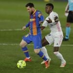 Vinícius pugna por un balón con Leo Messi en el Clásico del pasado sábado.