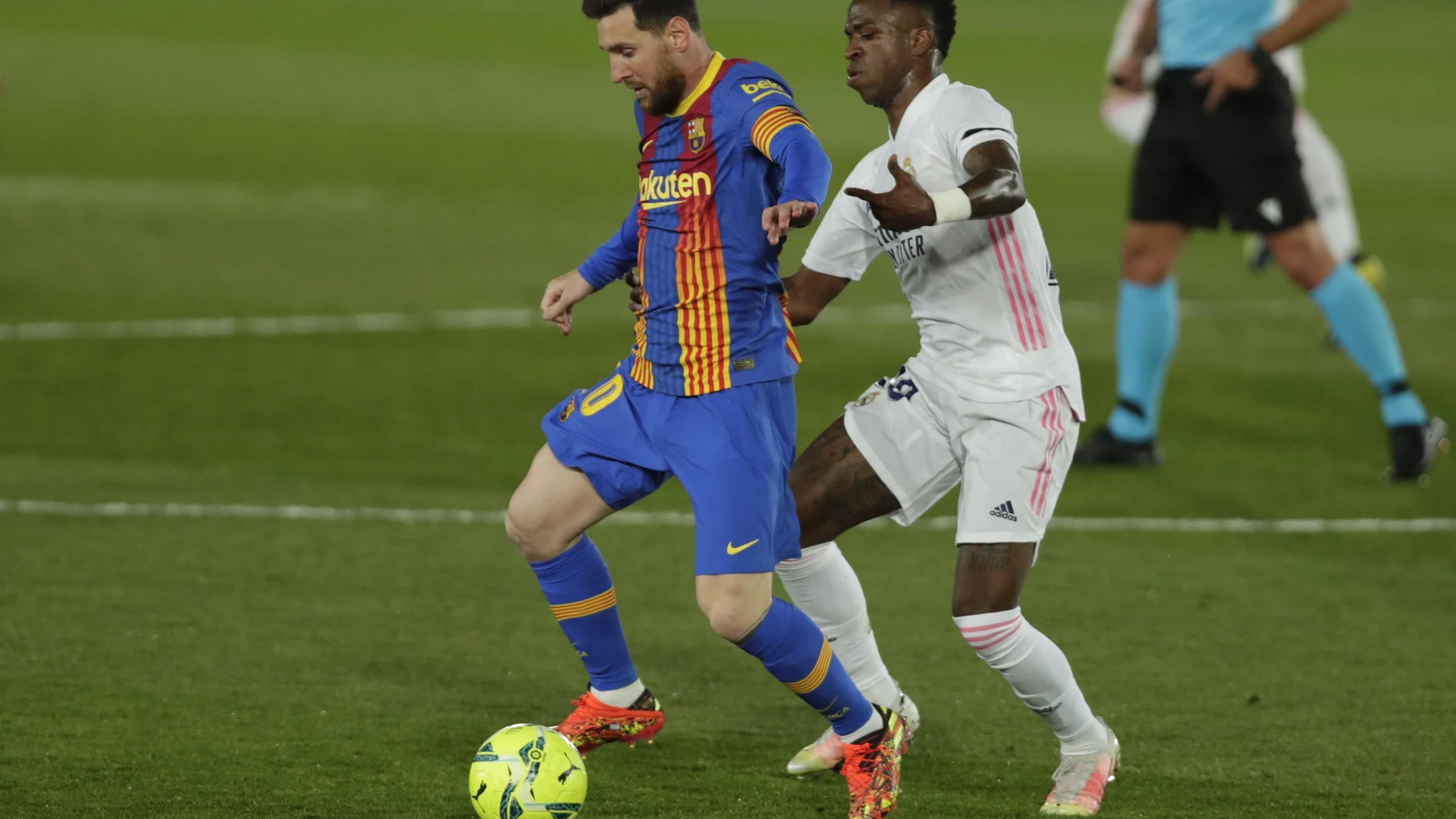 Vinícius pugna por un balón con Leo Messi en el Clásico del pasado sábado.