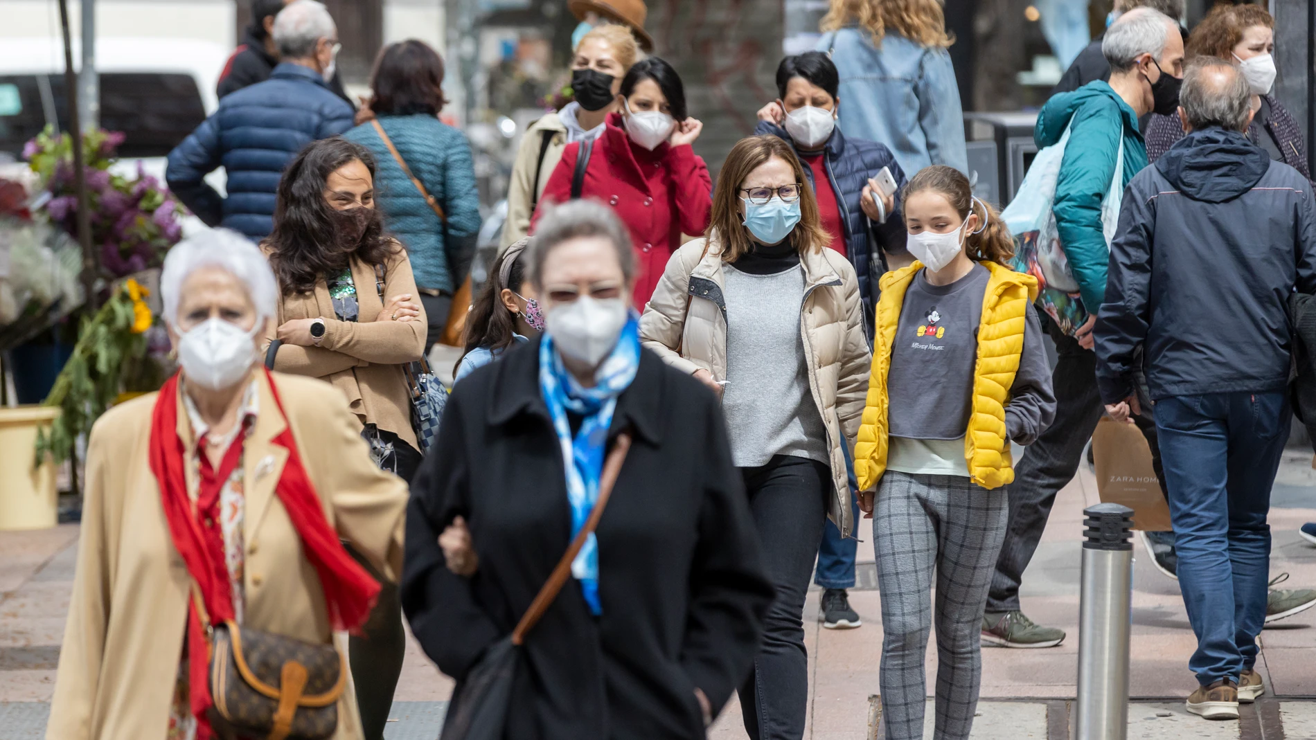 Ciudadanos por la calle con mascarilla