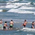 Un grupo de jóvenes disfruta de un baño en aguas de la playa de la Malvarrosa (Valencia)