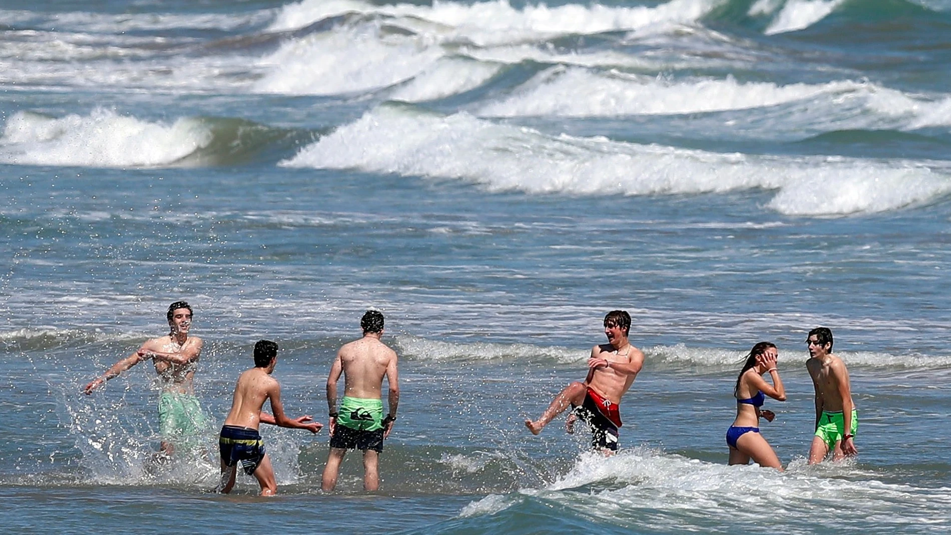 Un grupo de jóvenes disfruta de un baño en aguas de la playa de la Malvarrosa (Valencia)