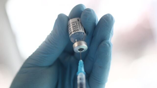 Un sanitario prepara una de las dosis de la vacuna Pzifer antes de suministrarsela a un anciano