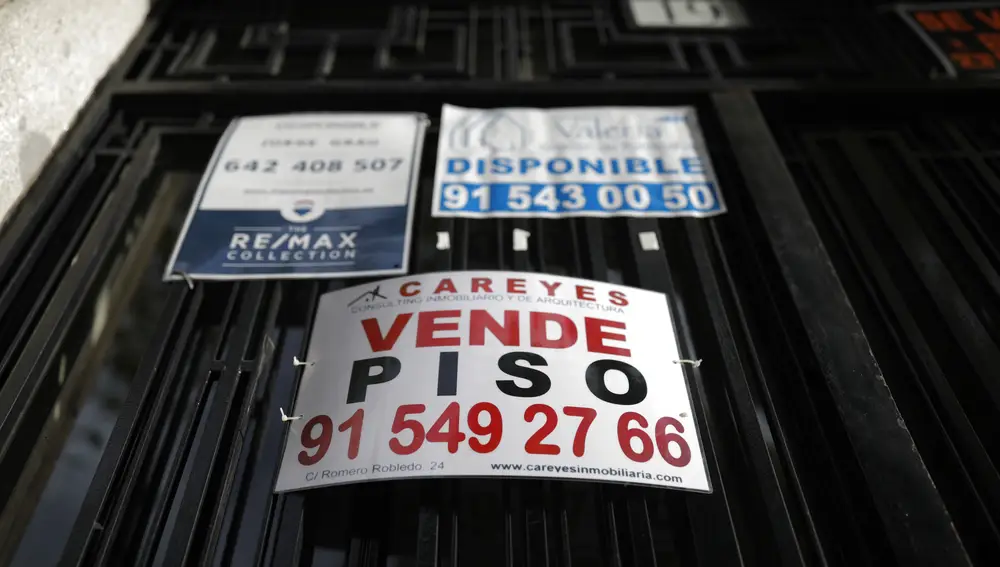 Carteles de Se Vende y se alquila en un portal del centro de Madrid. Se vende Piso.