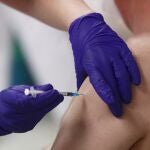 Una sanitaria inocula la primera dosis de la vacuna Pzifer a un anciano, en el Hospital Universitario de La Paz de Madrid
