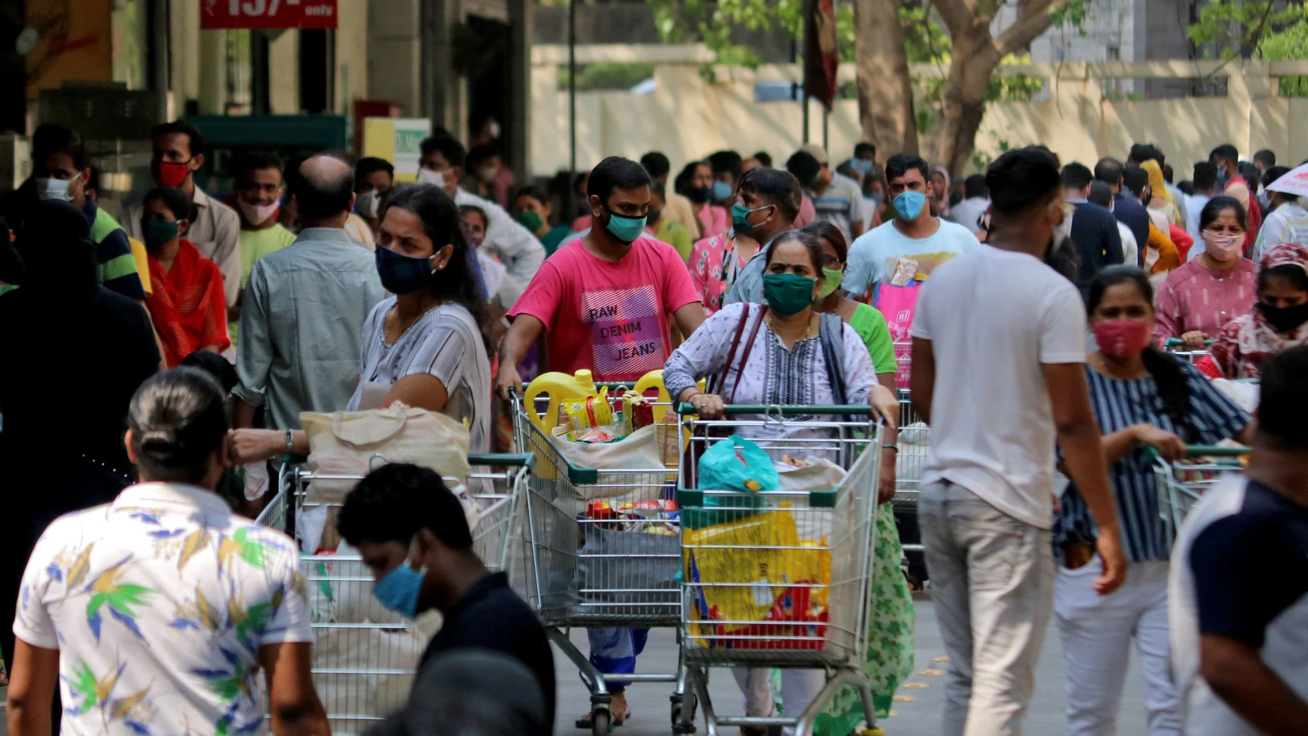 People push trolleys loaded with grocery items as others wait to enter a supermarket, amidst the spread of the coronavirus disease (COVID-19) in Mumbai, India, April 14, 2021. REUTERS/Niharika Kulkarni