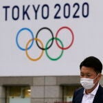 Tokyo (Japan), 14/04/2021.- A man walks past a banner with the logo of the Tokyo 2020 Olympic Games hanging from the wall of the Tokyo Metropolitan City Hall in Tokyo, Japan, 14 April 2021. Tokyo began the 100 days countdown until the Olympic Games opening ceremony. The Summer Olympic Games, rescheduled from 2020 to 2021 because of the COVID-19 pandemic, are set to start on 23 July 2021. (Abierto, Japón, Tokio) EFE/EPA/KIMIMASA MAYAMA