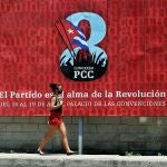 Una mujer camina hoy frente a una valla que promociona el VIII Congreso del Partido Comunista de Cuba