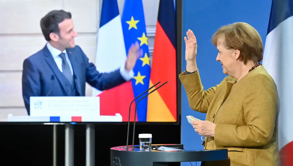 El francés Emmanuel Macron y la alemana Angela Merkel se saludan tras una conferencia de prensa telemática