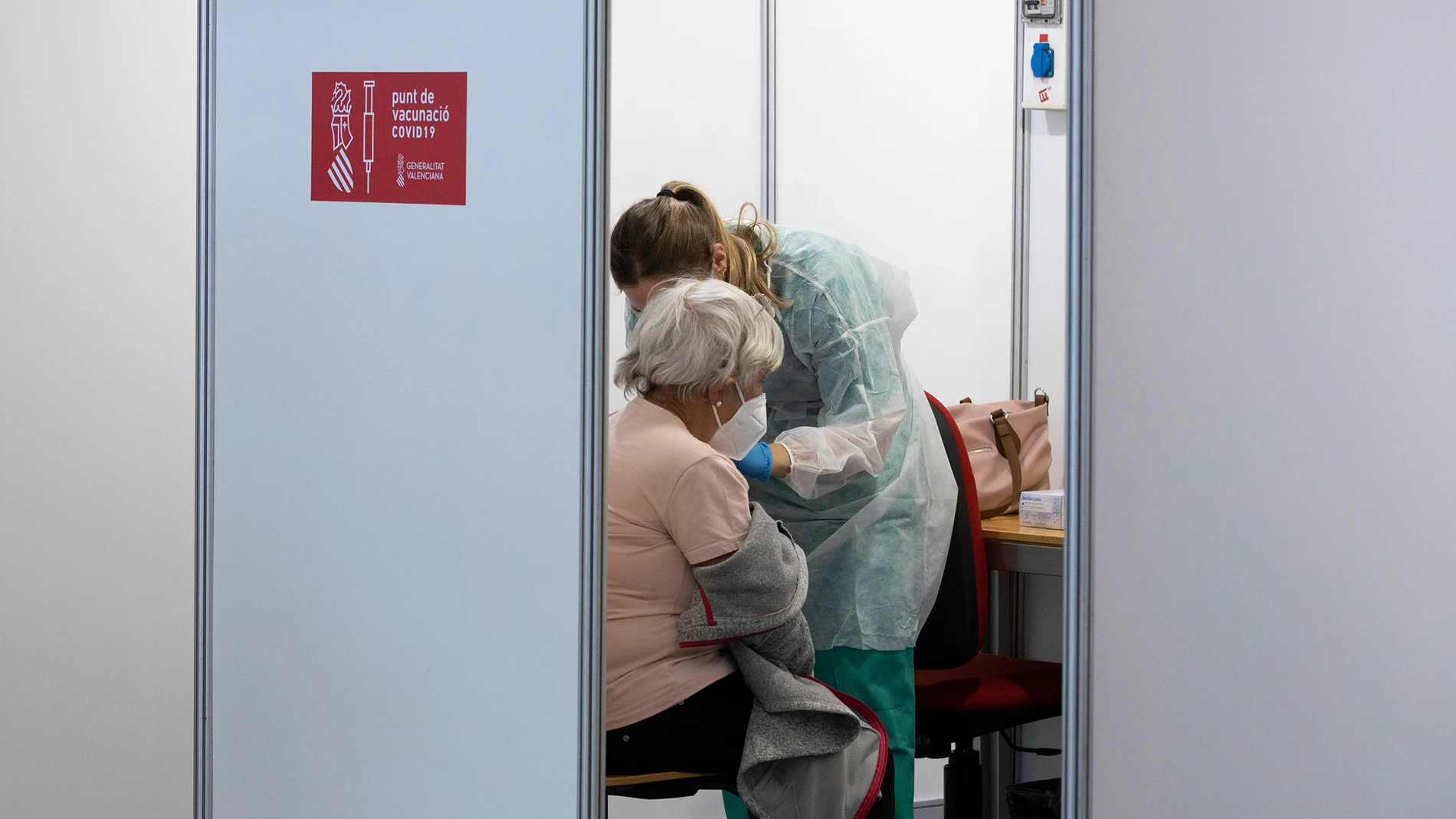 Una sanitaria vacuna a una mujer en el primer día de la vacunación masiva en la Comunidad Valenciana