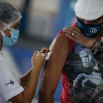 AME1043. RIO DE JANEIRO (BRASIL), 20/04/2021.- Un hombre recibe la dosis de la vacuna de Astrazeneca contra la covid-19 hoy, en la cuadra de Portela, una de las comparsas de carnaval más tradicionales de Río de Janeiro (Brasil). Brasil es el segundo país con más fallecidos, detrás de Estados Unidos, aunque actualmente es el lugar del planeta donde más se muere por covid-19. En cuanto a contagios, la potencia suramericana se ubica en el tercer lugar, después de EE.UU e India. EFE/André Coelho