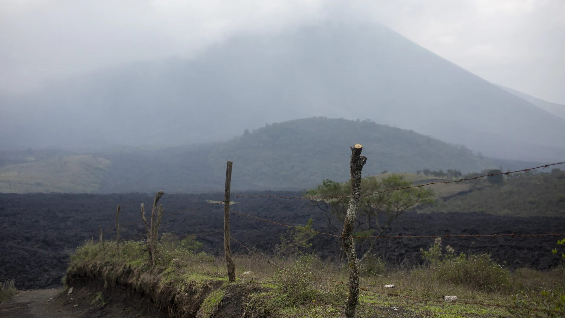 Shrouded by clouds and volcanic ash particles, lava flows down the slopes of the Pacaya Volcano, near El Patrocinio village in San Vicente Pacaya, Guatemala, Wednesday, April 21, 2021. The 8,373-foot volcano, just 30 miles south of Guatemalaâ€™s capital, has been active since early February. (AP Photo/Moises Castillo)